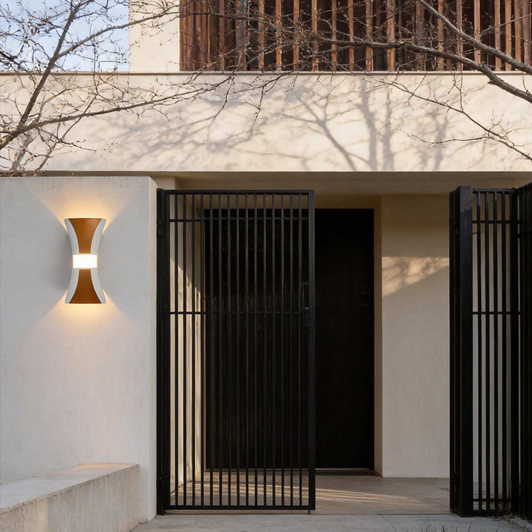 Hourglass wall light enhancing a contemporary outdoor wall with elegant ambient light.