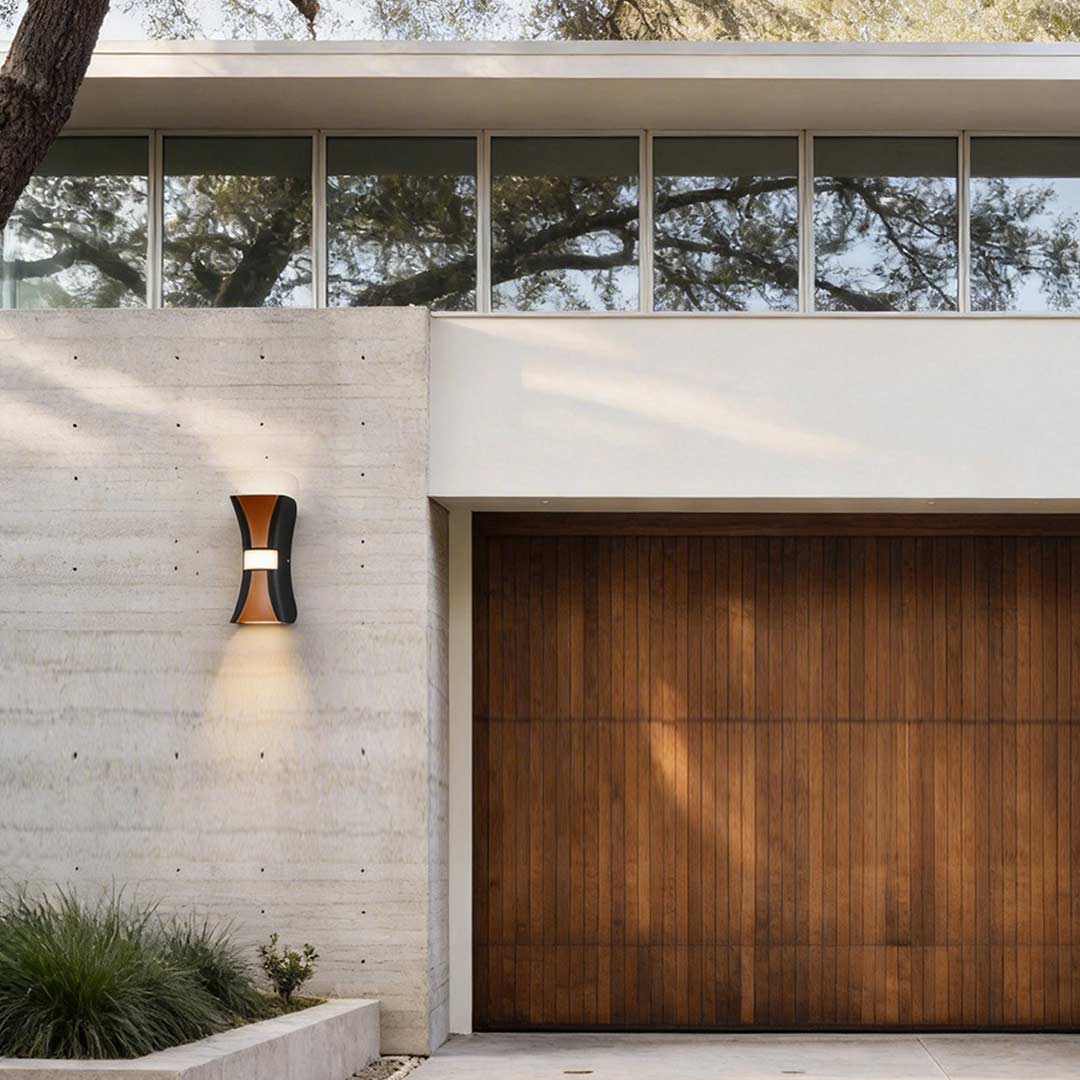 Hourglass wall light illuminating a modern house entrance with warm directional glow.