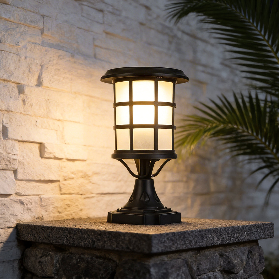 House pillar lights with a black finish, enhancing a stone pillar in a garden.