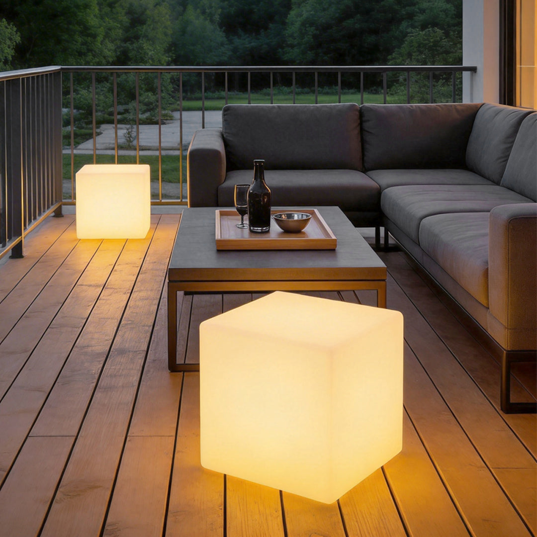 Ice cube LED lights used as modern outdoor tables with warm illumination on a wooden deck.