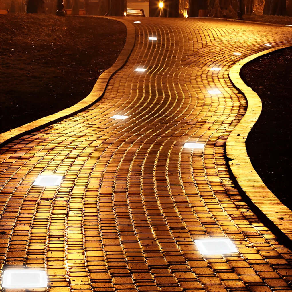 Ice cube pathway lights embedded in a brick walkway at night.