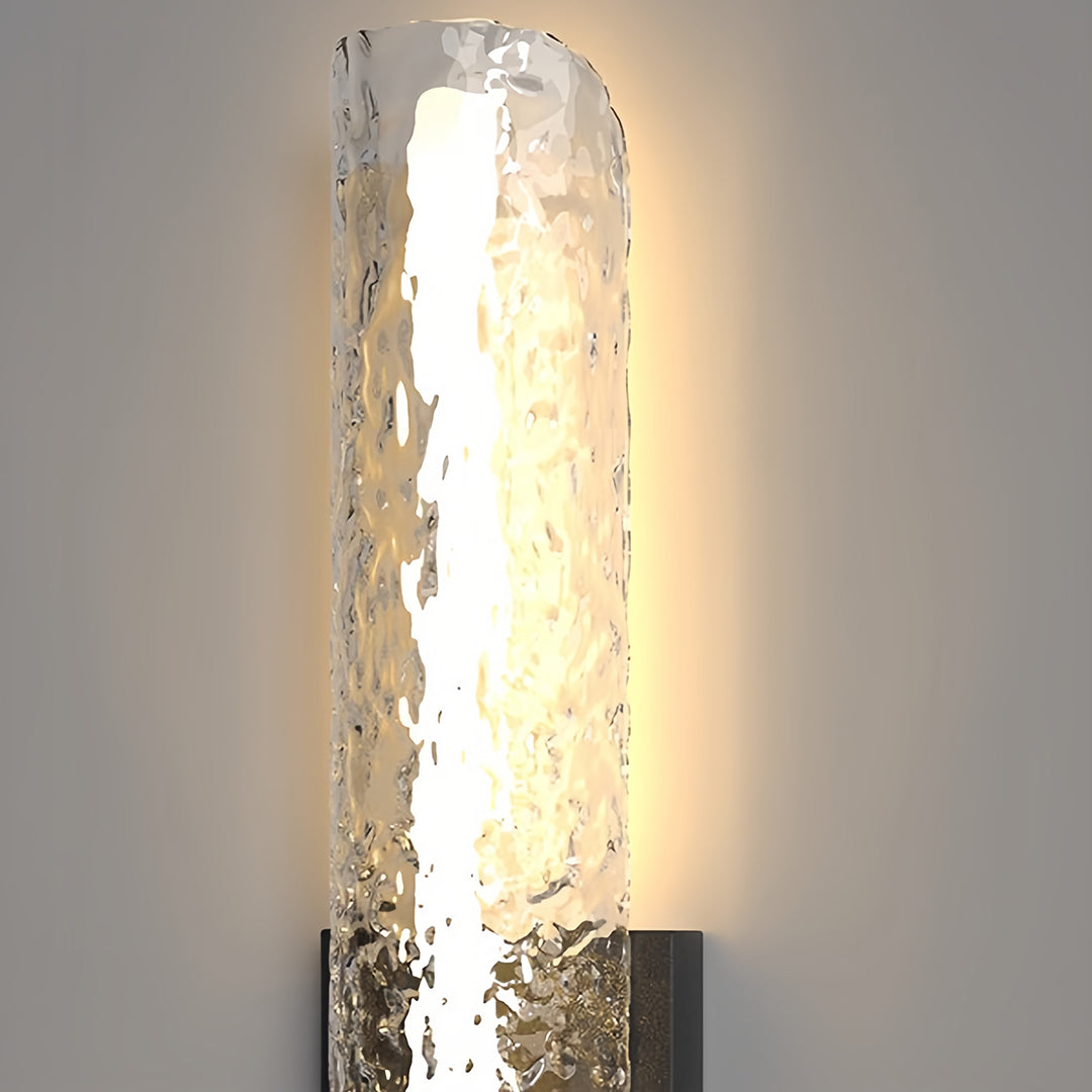 Illuminated contemporary black outdoor wall light highlighting the beautiful warm glow through the bubble glass texture.