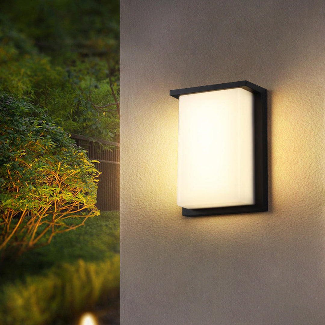 Illuminated outdoor wall light creating warm ambient glow on modern house exterior at night