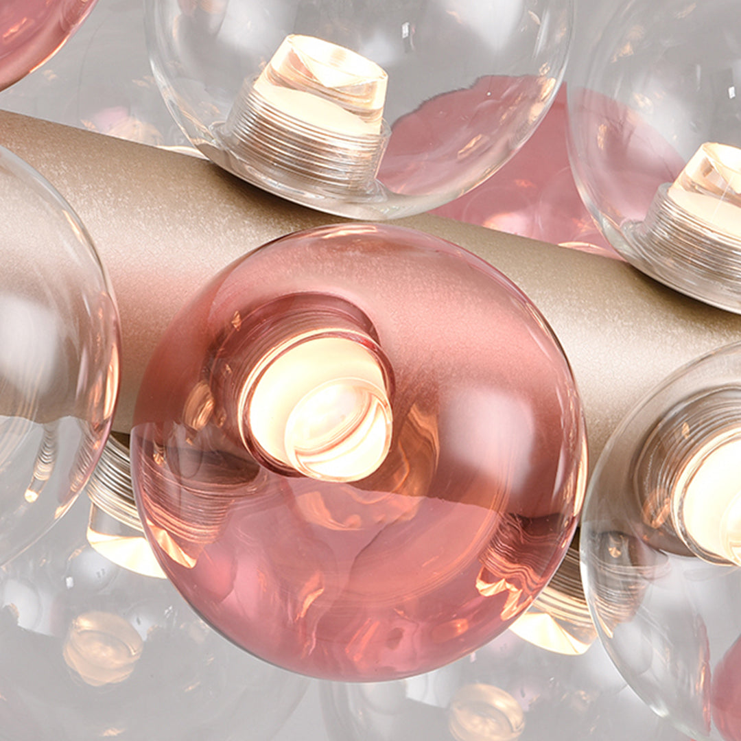 Close-up detail of illuminated rose-colored glass orb showing warm light diffusion and transparency