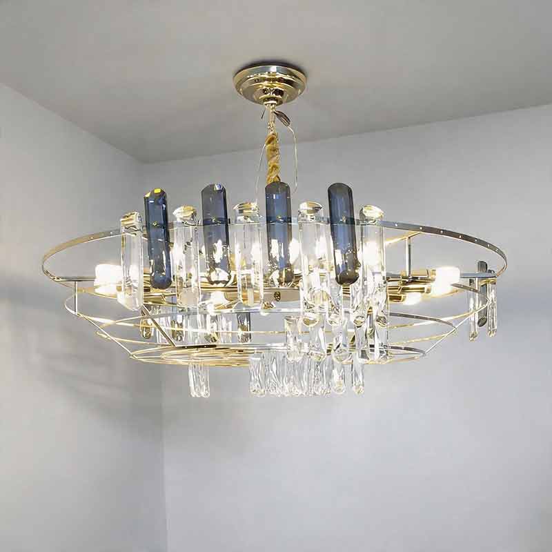 Illuminated round drum crystal chandelier​ hanging in a modern space with clear and dark glass.