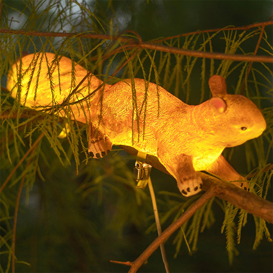 Illuminated solar animal light in shape of golden squirrel creating warm garden ambiance at night