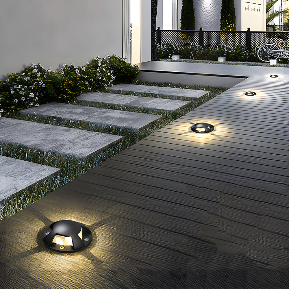 In-ground low voltage landscape lighting along a garden pathway, blending seamlessly with stone paving.