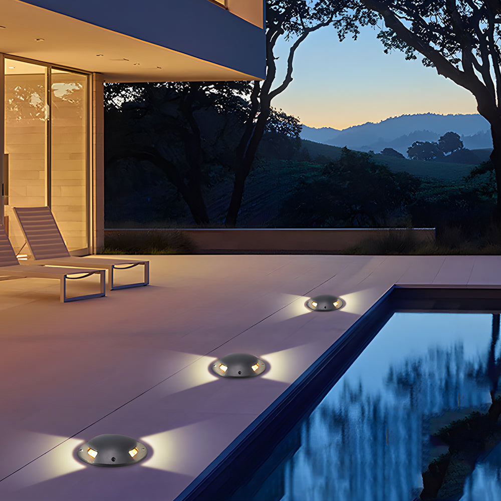 In-ground low voltage landscape lighting around a pool deck, creating a serene and inviting outdoor evening atmosphere.