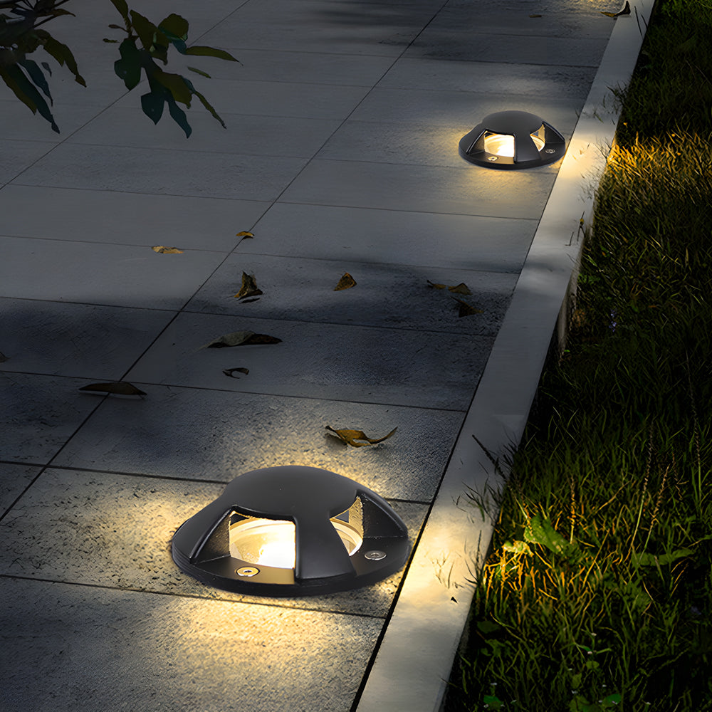 In-ground low voltage landscape lighting fixture with warm light, ideal for highlighting outdoor garden features.