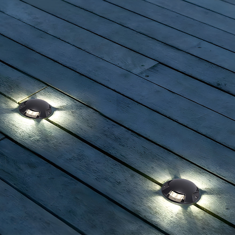 Close-up of in-ground low voltage landscape lighting embedded in wooden decking, offering focused illumination.