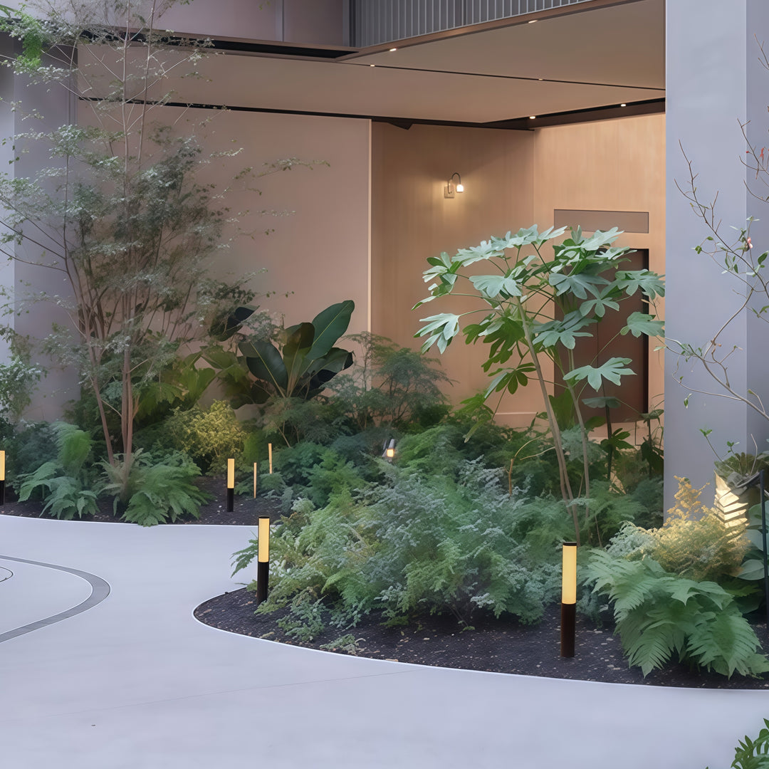 Indoor courtyard-style garden scene featuring several led bollard garden light fixtures integrated into plant beds.