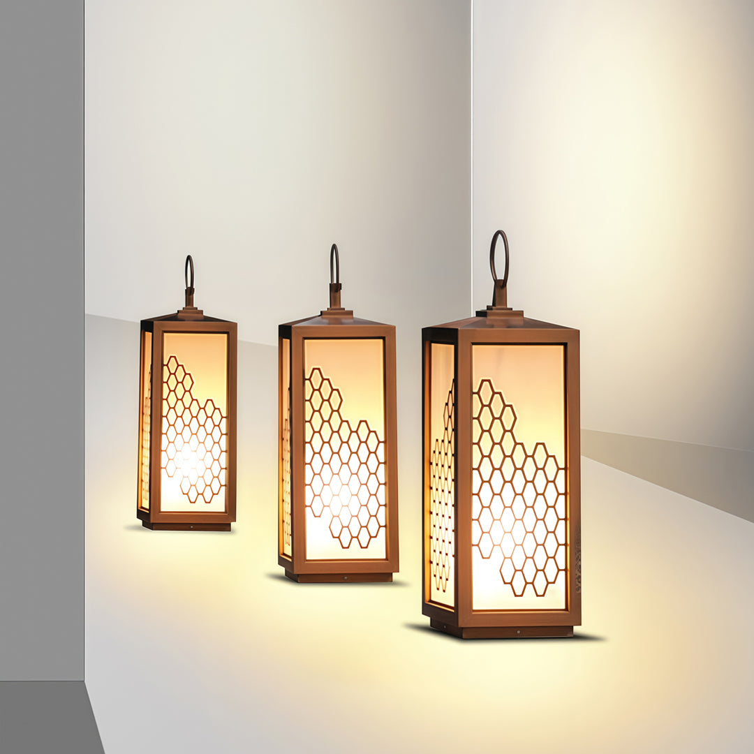 Set of hanging lantern-style bollard lighting fixtures emitting warm soft light in a minimal interior.