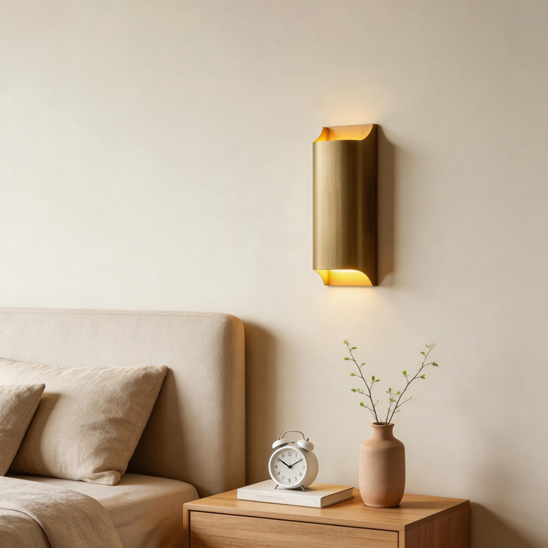 Minimalist bedroom corner illuminated by brass wall light indoor spotlight lamp with soft warm illumination.