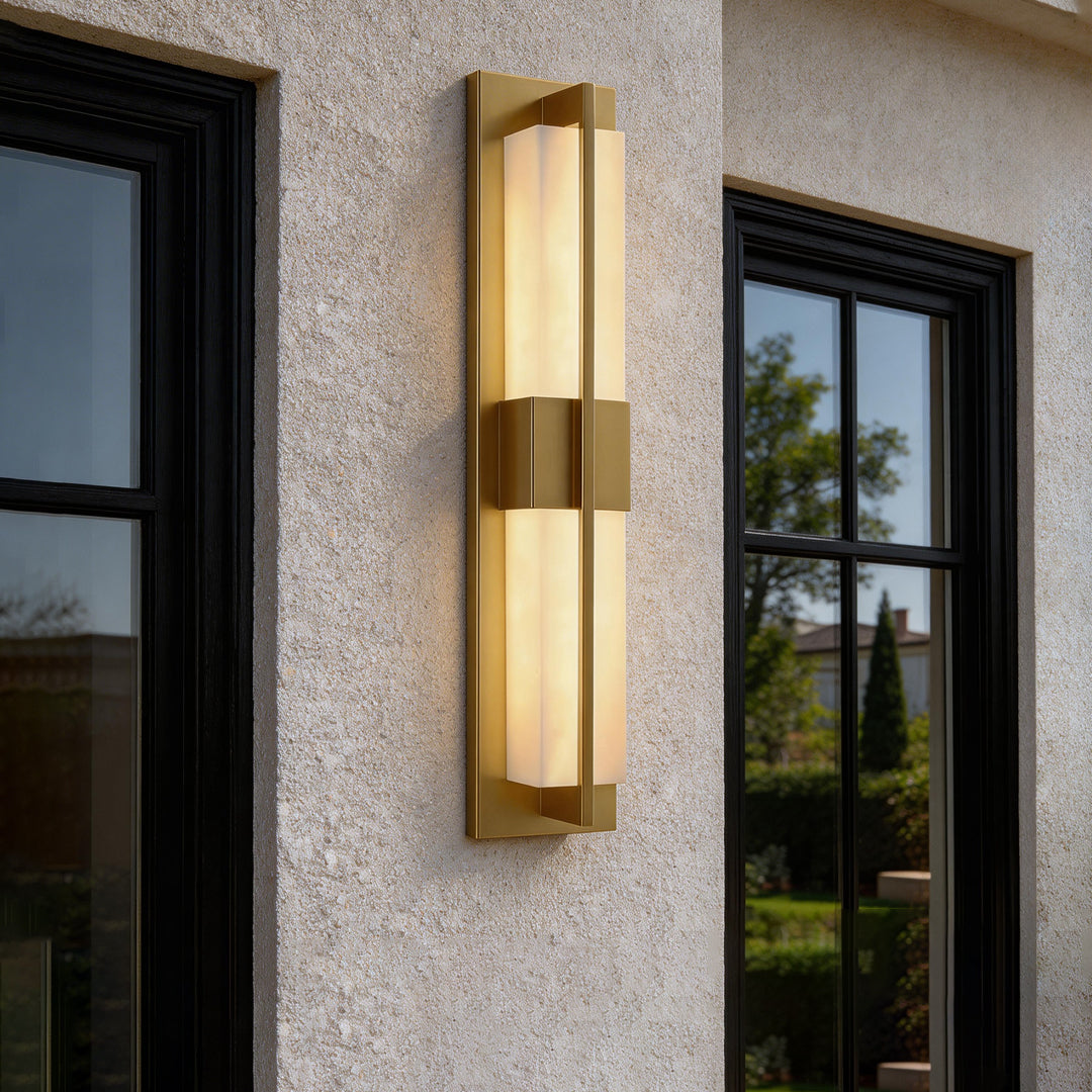 Modern outdoor facade featuring gold wall lighting indoor spotlight lamp beside window with soft ambient light.