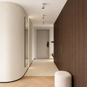 Indoor spotlight lamp mounted on the ceiling in a contemporary hallway with white walls and natural light.