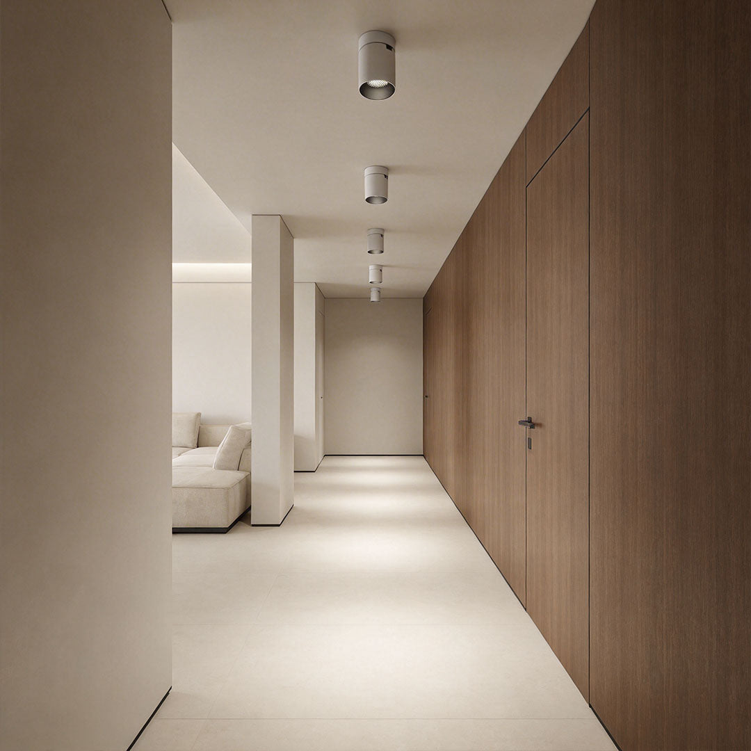 Indoor spotlight lamp placed on the ceiling in a cozy living room with wooden paneling and soft lighting.