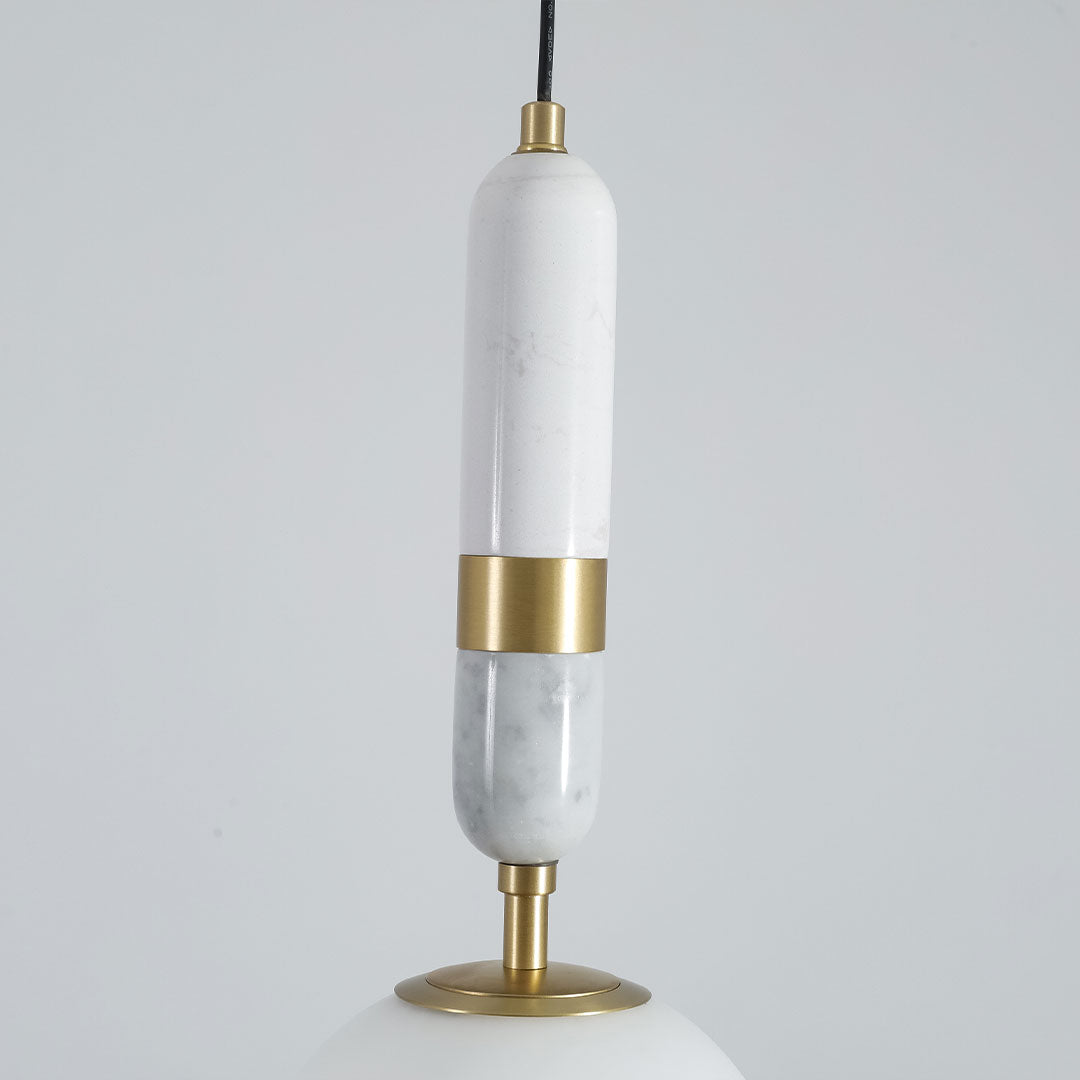 Detailed view of modern globe pendant light indoor spotlight lamp with marble and brass decorative element.