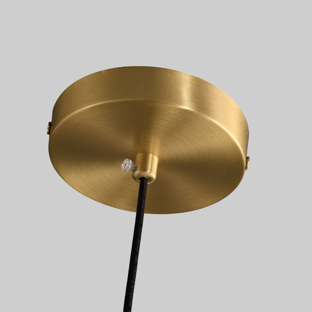 Detail view of vintage glass light pendant indoor spotlight lamp ceiling mount with brushed brass finish.
