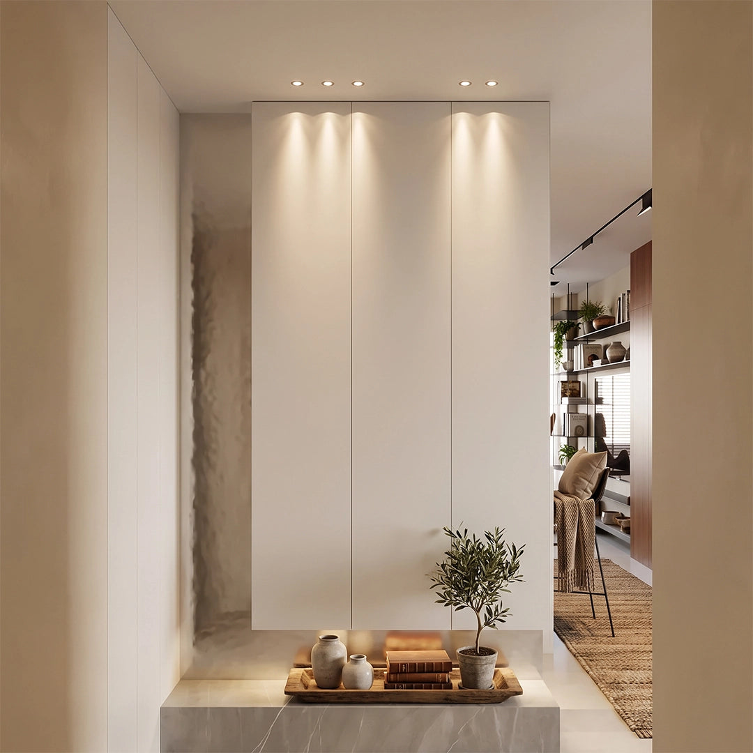 Indoor spotlights shining down on a tall wall niche with decorative objects and soft warm light.