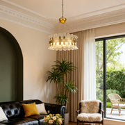 Luxurious gold candle-style chandelier in a bright living room with large windows