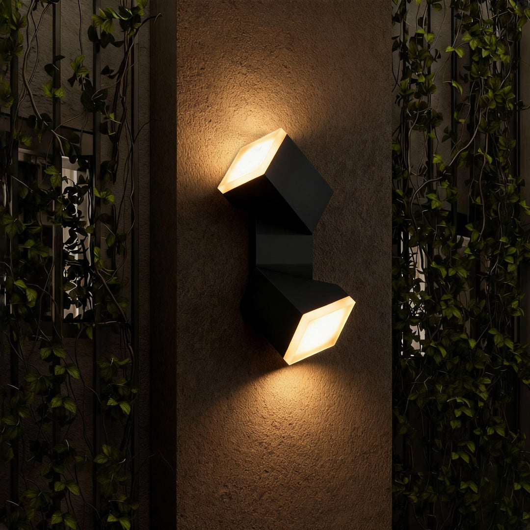 Warm outdoor dual-direction wall light illuminating greenery, creating a soft glow comparable to industrial bollard lights.