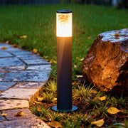 Industrial bollard lights placed beside landscaped stones, providing bright vertical illumination for outdoor pathways.