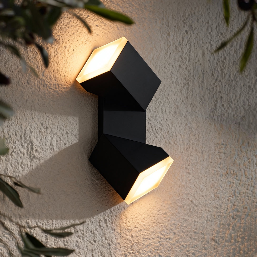 Outdoor dual-beam wall lamp placed on a textured surface, showcasing warm light beams similar in style to industrial bollard lights.