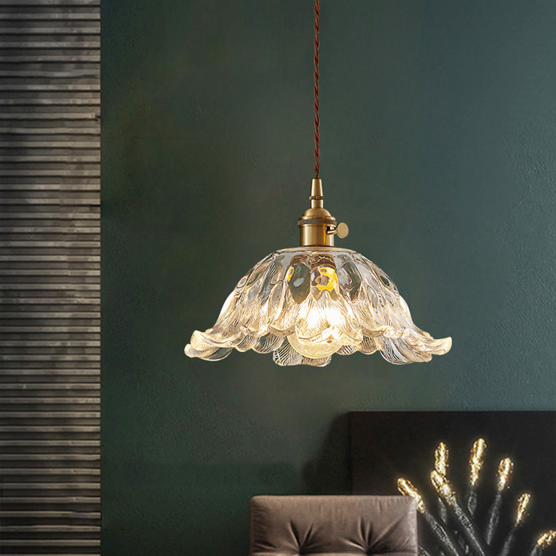 Industrial flower pendant lighting with brass fittings creating sophisticated task lighting in dark interior.