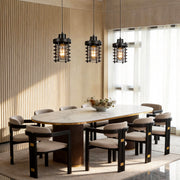 Industrial cage pendant lights hanging above a modern dining table with warm ambient lighting.