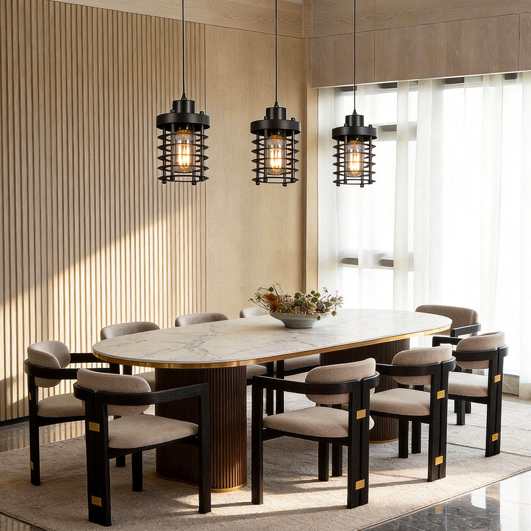 Industrial cage pendant lights hanging above a modern dining table with warm ambient lighting.