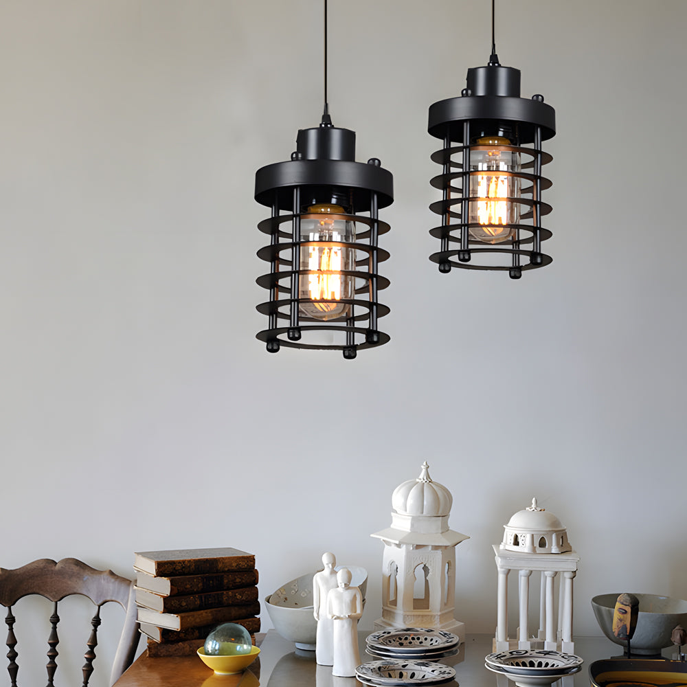 Pair of industrial cage pendant lights displayed in a minimalist dining room.