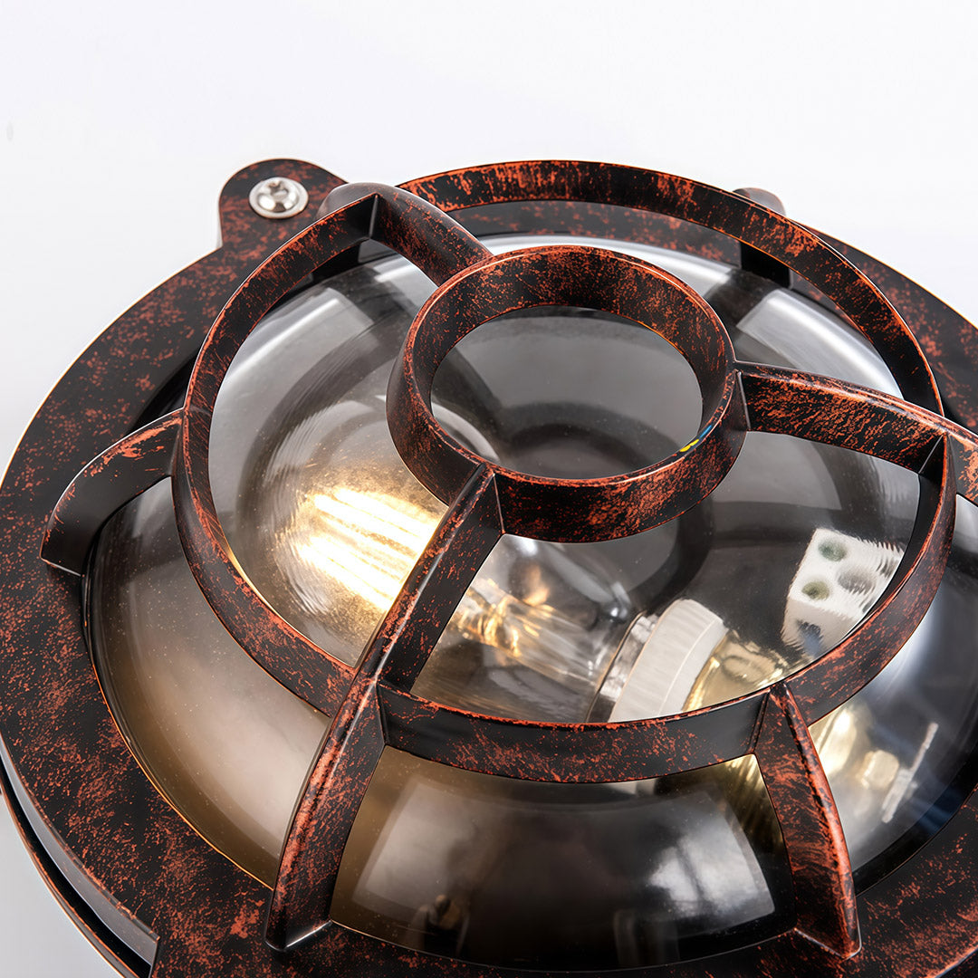 Industrial outdoor sconce wheel-shaped fixture with copper patina finish and cross-bar protective cage design