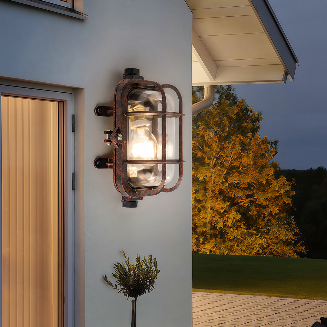 Industrial outdoor sconce beside wooden door on residential facade providing architectural accent lighting outdoors