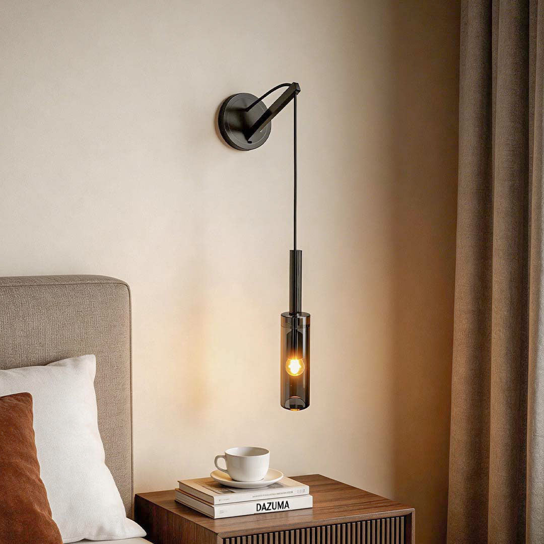 Industrial style bedside hanging wall lamp installed above a wooden nightstand with coffee and books.