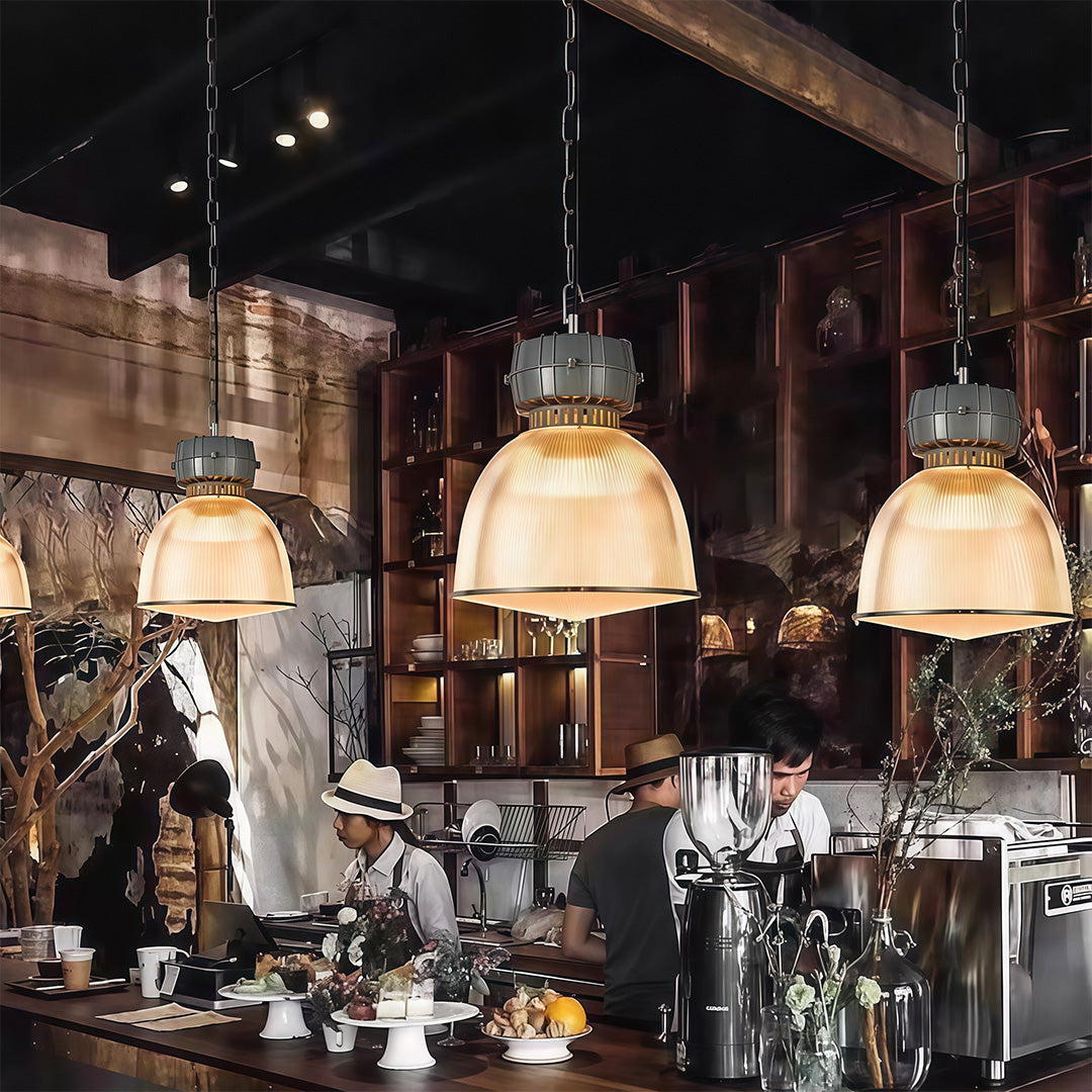 Multiple industrial style pendant lighting fixtures in busy cafe interior creating vintage atmosphere ambiance