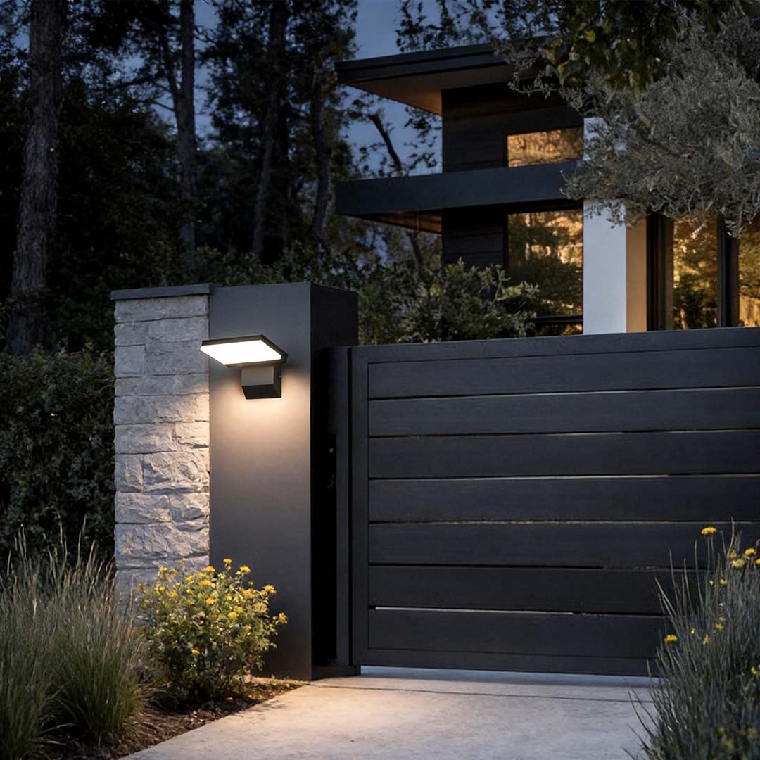 Industrial wall light enhancing a contemporary garden fence with warm illumination.