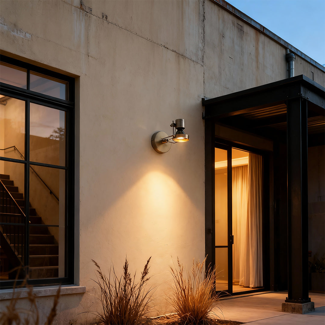 Industrial wall lights installed flanking entrance doorway providing dramatic architectural accent lighting outdoors