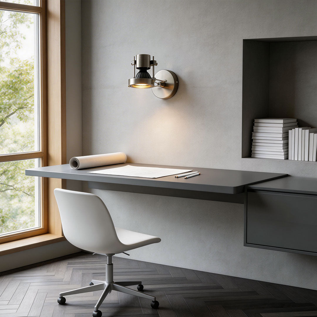 Sleek metallic industrial wall lights mounted above a floating desk and the white office chair.