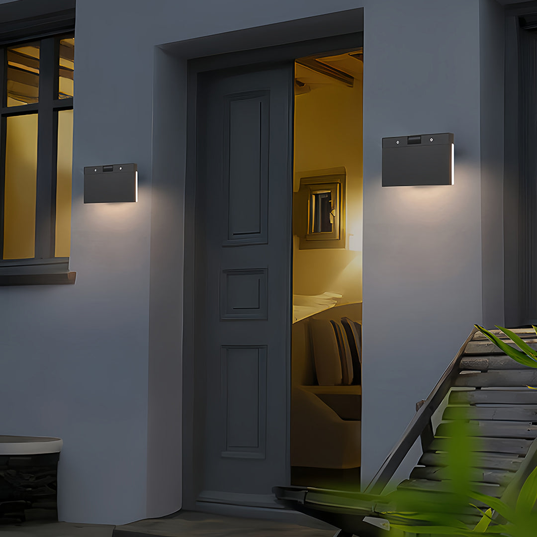 Industrial wall lights installed on modern gray exterior walls creating ambient outdoor lighting