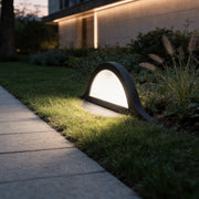 Inground landscape lights with a sleek design, illuminating a garden pathway at dusk.