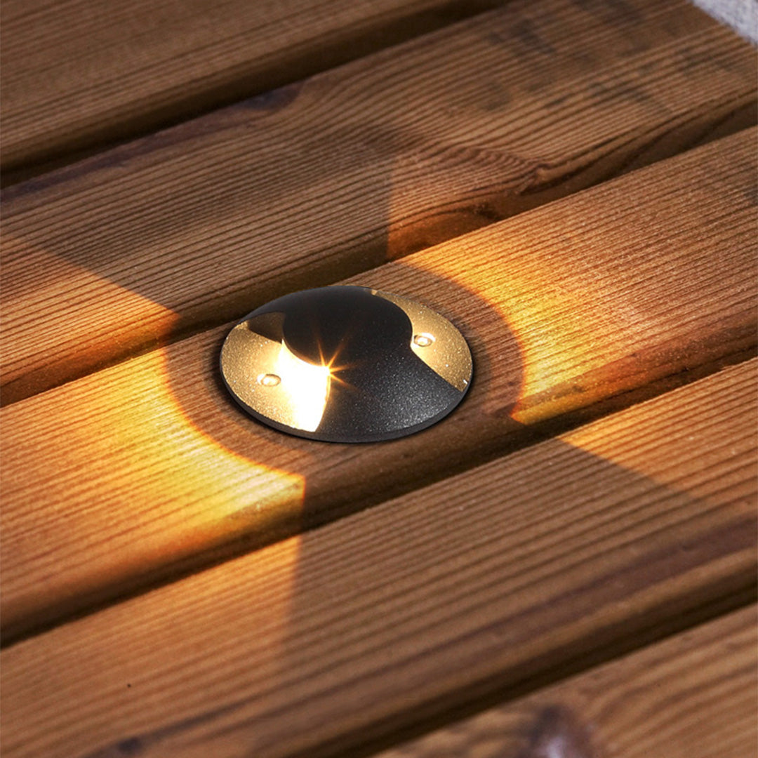 In-ground landscape lights creating dramatic uplighting effects on outdoor pathway at dusk