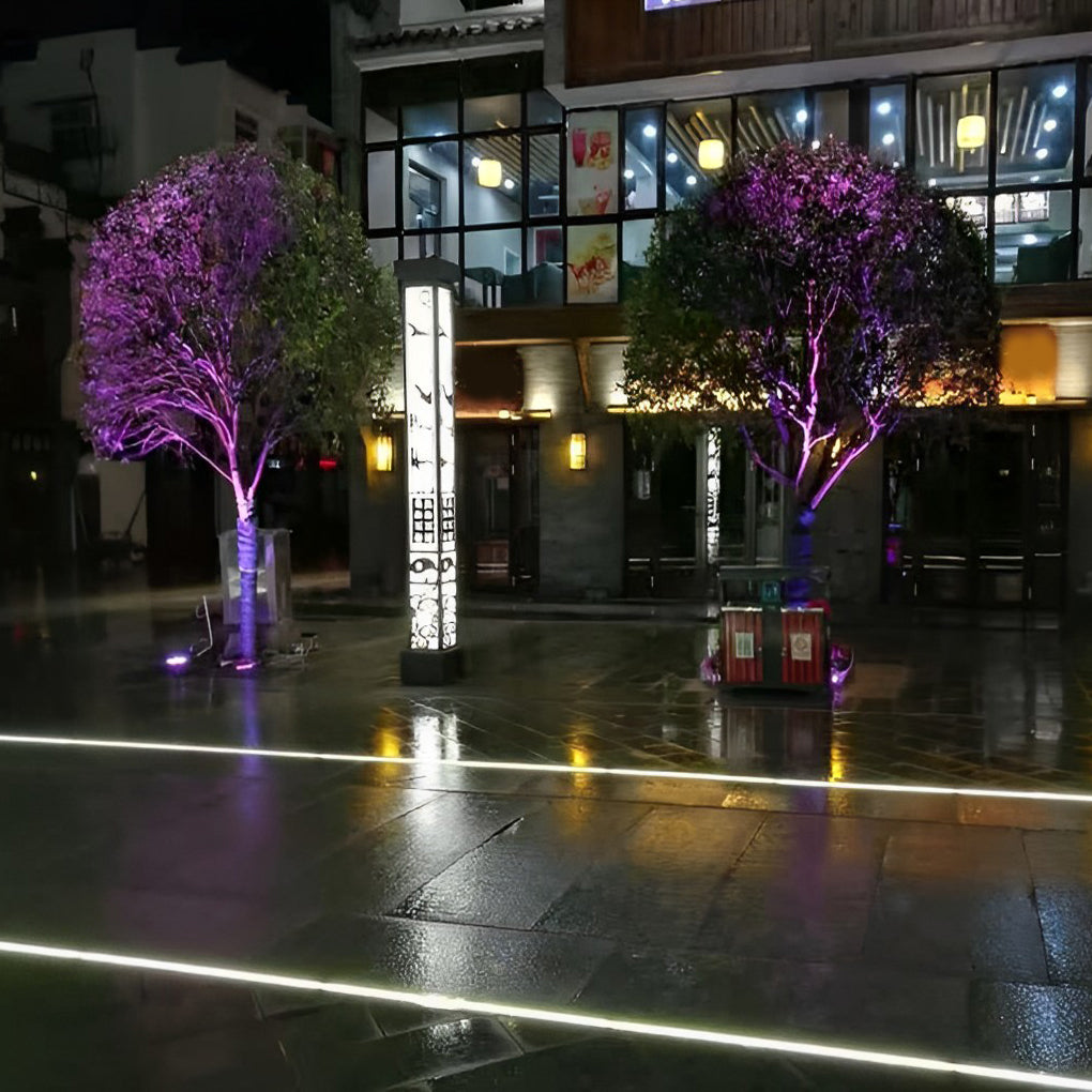 Inground linear lighting enhancing a contemporary urban plaza at night.