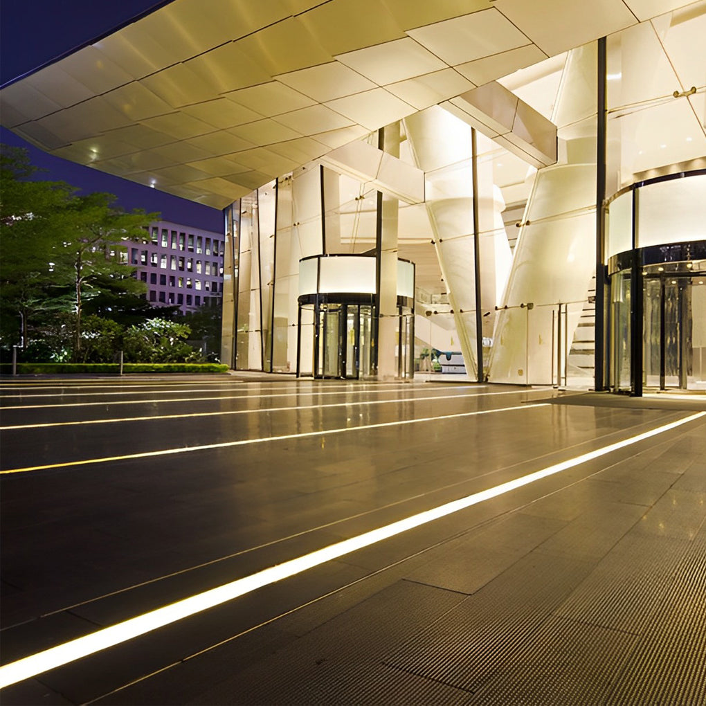 Inground linear lighting providing elegant illumination in a commercial building entrance.