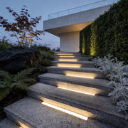 Inground linear lighting illuminating modern outdoor steps with a sleek, warm glow.