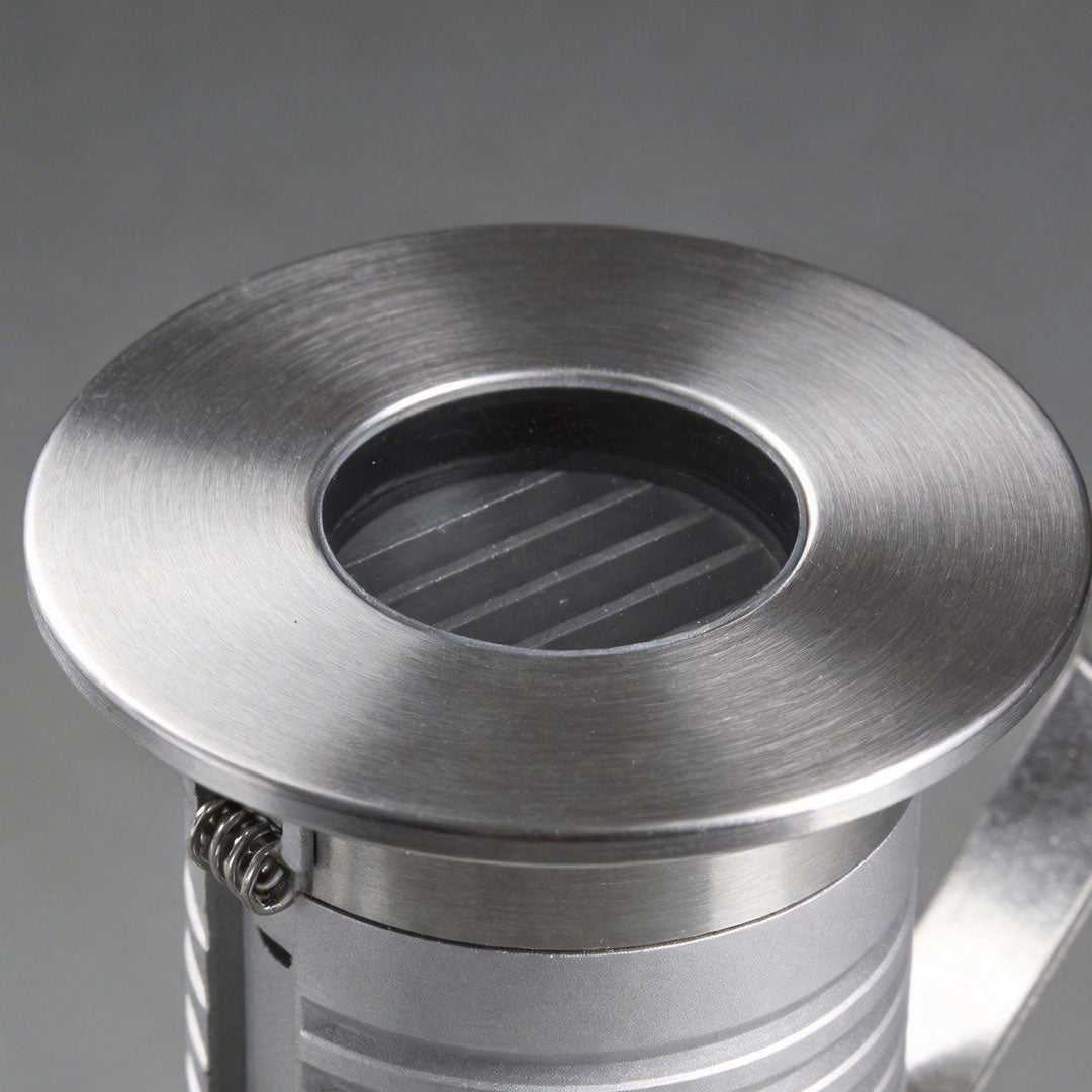 Inground well light with a sleek design, mounted on a concrete surface.