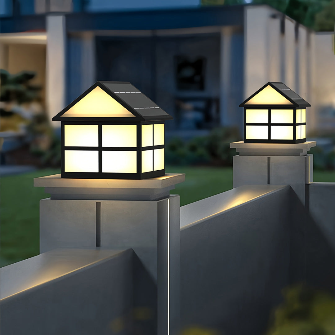 Outdoor night scene showing gate pillar top lights installed on modern boundary walls, creating a warm and inviting glow.