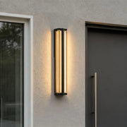 Wall mount outdoor lighting installed beside a modern entry door with warm architectural lighting.