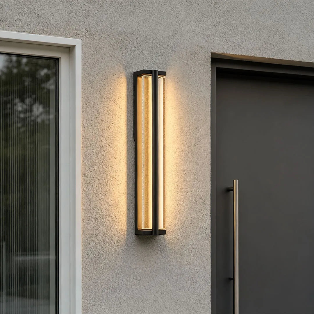 Wall mount outdoor lighting installed beside a modern entry door with warm architectural lighting.