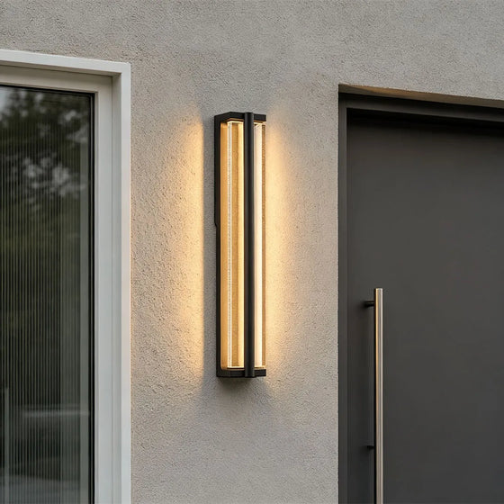 Wall mount outdoor lighting installed beside a modern entry door with warm architectural lighting.