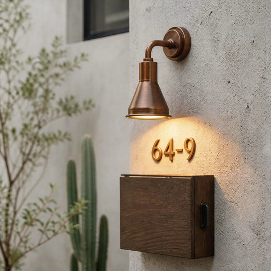 Wall sconces outdoor lighting installed beside a house number with warm exterior illumination.